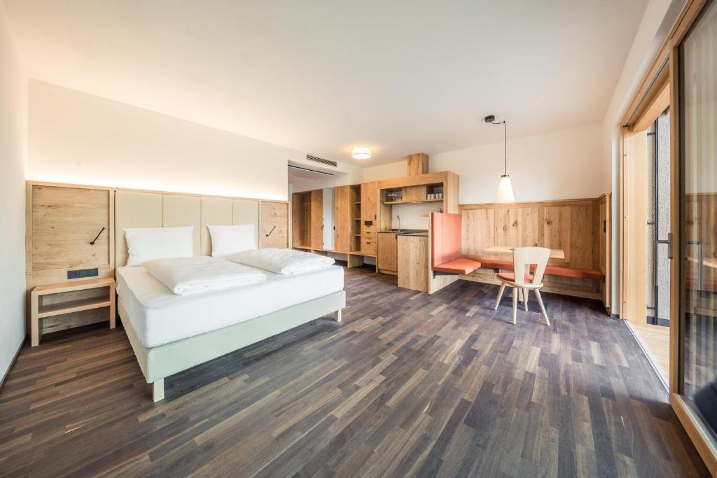 1 dormitorio con cama, escritorio y mesa en Weingut Moser Apartments, en Caldaro