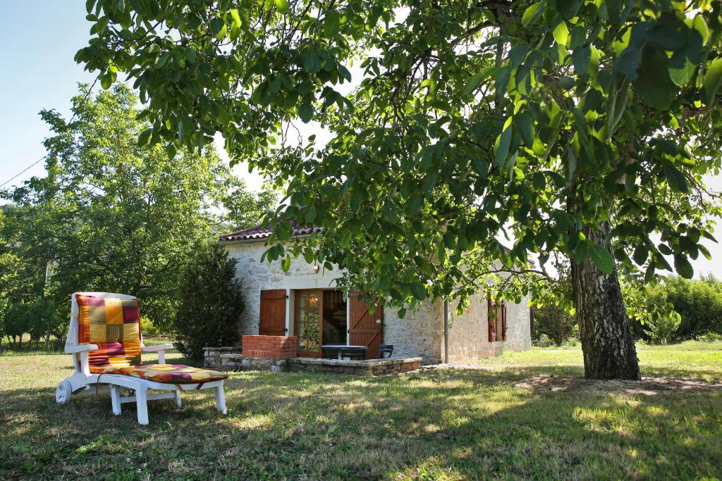 un banc devant une maison avec un arbre dans l'établissement GITE LA TENGNE, à Parnac