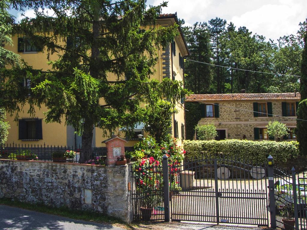ein gelbes Haus mit einem Zaun davor in der Unterkunft Alloggio Villa Manini in Scarperia