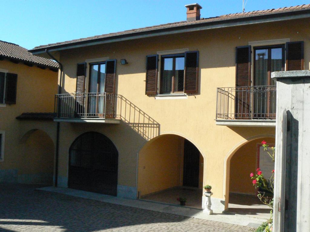 a yellow building with arches and windows and a fire hydrant at Villa Elma in Cigliè