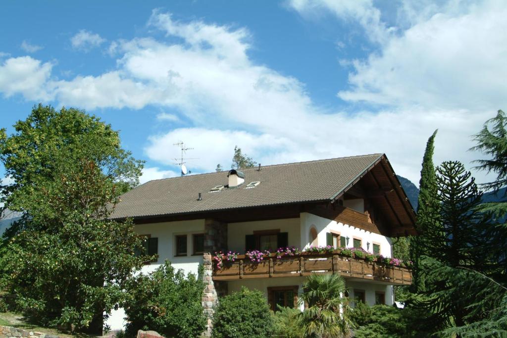 ein Haus mit einem Balkon mit Blumen darauf in der Unterkunft Oberjaistenhof in Lana