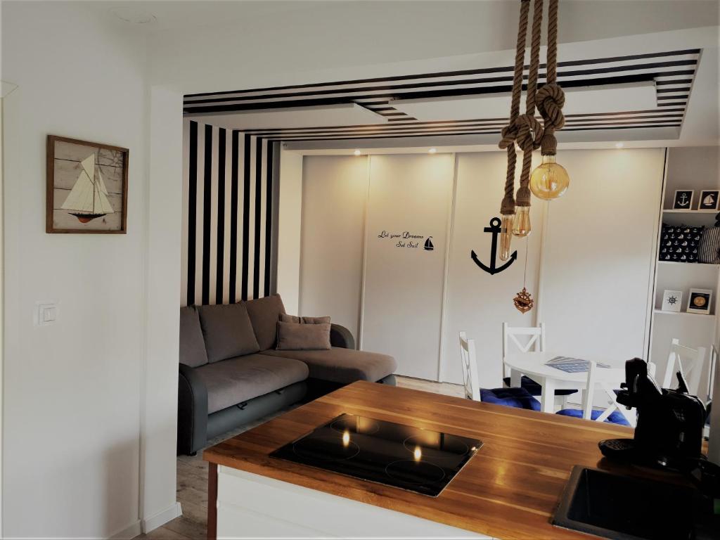 a kitchen and living room with a couch and a table at Apartament 200m do plaży in Gdańsk