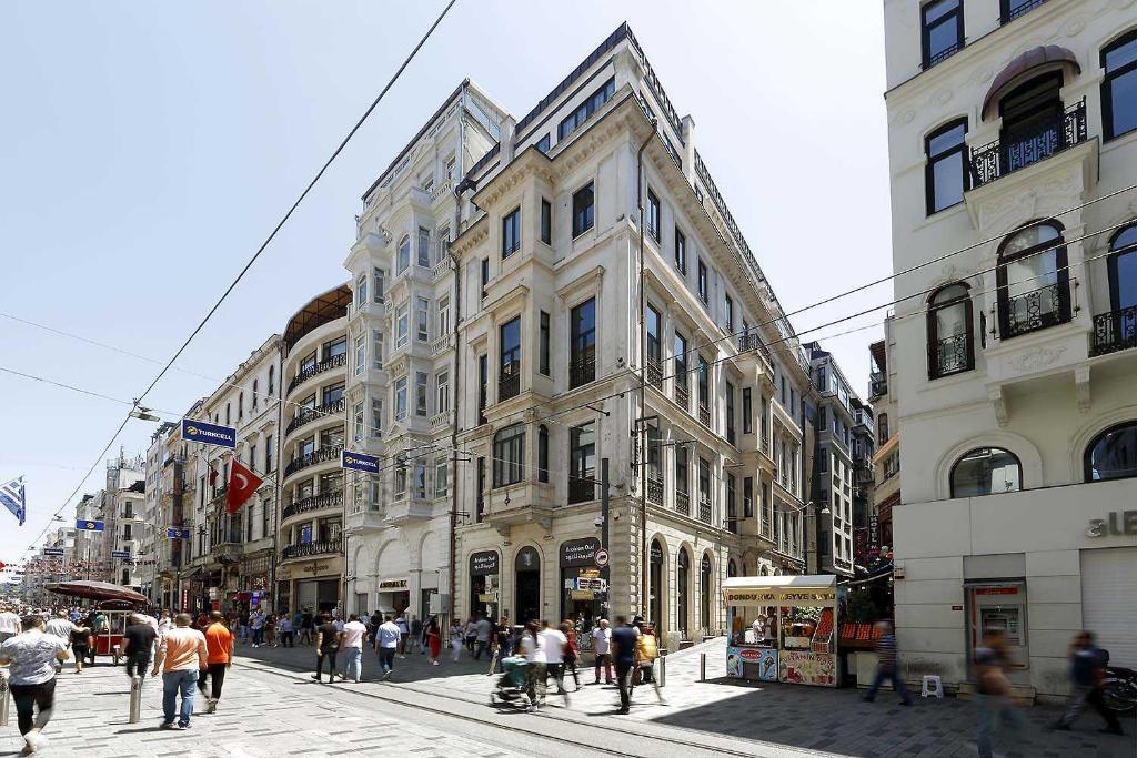 un grupo de personas caminando en una calle frente a los edificios en Hotel The Public - Special Category, en Estambul