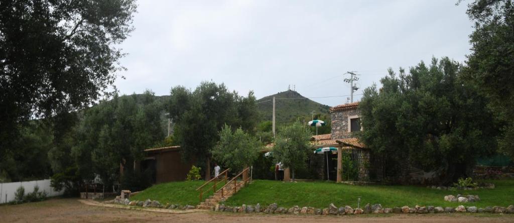 una casa con un patio con árboles y un edificio en Le Case di Arconte, en Marina di Camerota