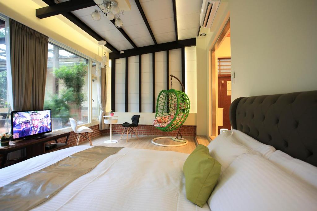 a bedroom with a bed and a desk and a television at Zhen Shan Zhuang B&amp;B in Yuanshan