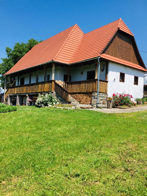 a house with an orange roof on a green field at Miklós Lak in Ocna de Sus