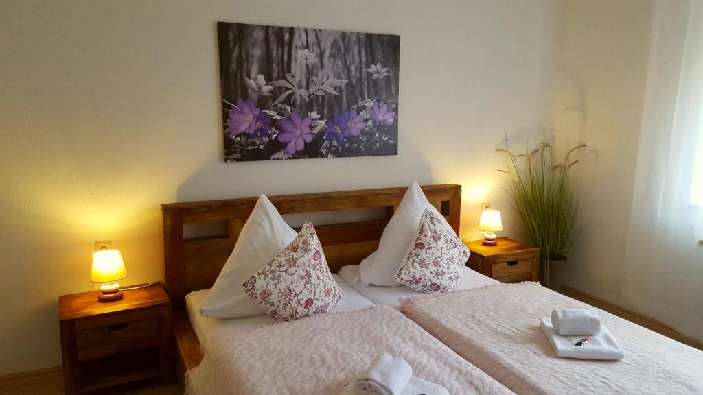 a bedroom with a bed with two lamps and a picture at Idylle am See in Zossen