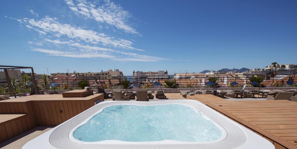 a large swimming pool with a balcony overlooking a city at Best Western Premier Le Patio des Artistes Wellness Jacuzzi in Cannes