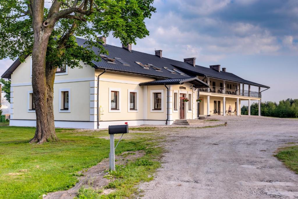 uma grande casa branca com um telhado preto em Folwark Żabowo em Glinojeck