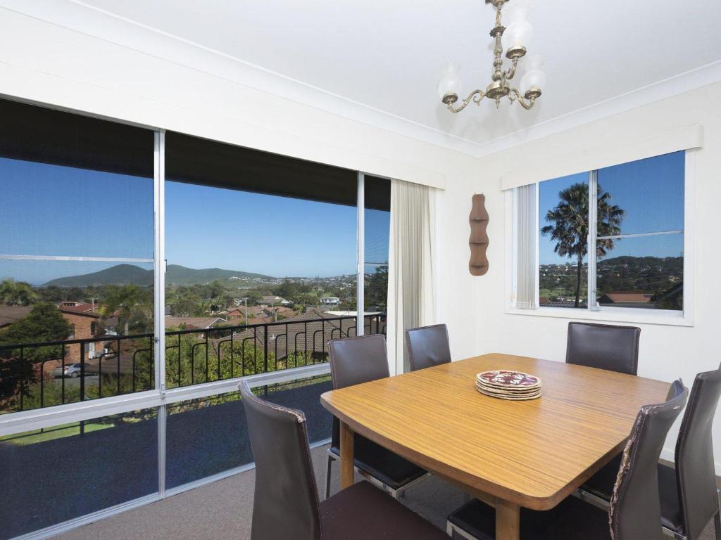 a dining room with a table and chairs and a balcony at Capeview in Forster