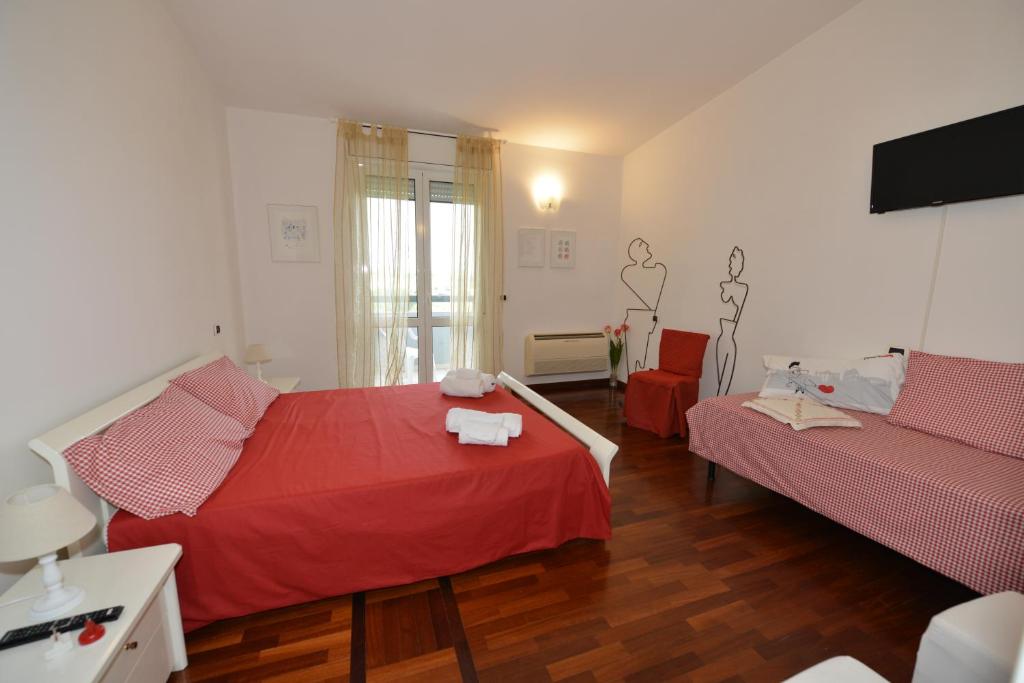 a bedroom with two beds with red sheets at B&B LA CASA DEL CASALE in Roseto degli Abruzzi