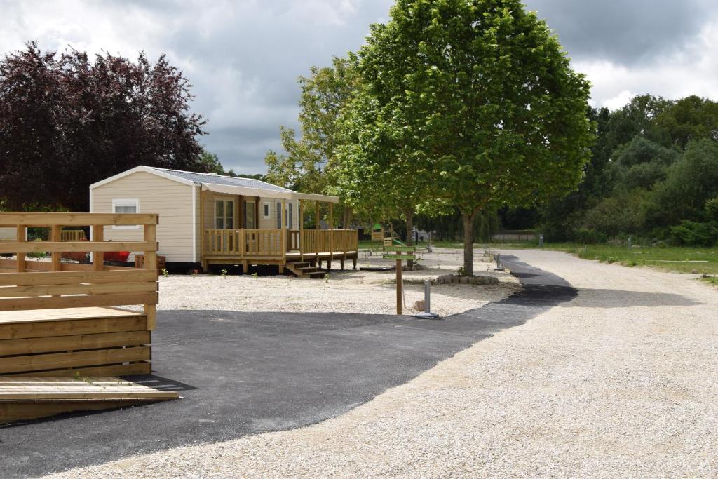 a small cabin with a tree and a building at Camping des Joyeux Campeurs in Pont-sur-Seine