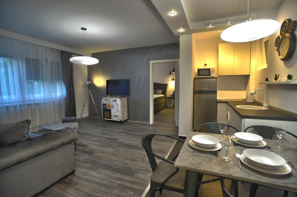 a kitchen and a living room with a table and a couch at Apartment A in Belgrade