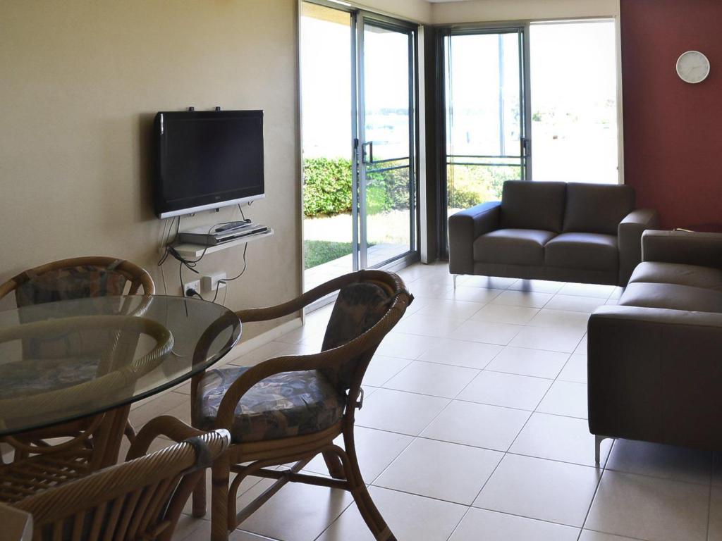 a living room with a tv and a table and chairs at Fairholme 5 in Tuncurry