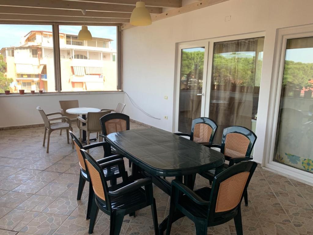 a dining room with a table and chairs and windows at Double Room with Terrace in Golem