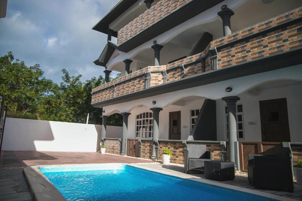 une maison avec une piscine en face de celle-ci dans l'établissement Villa Canne Rouge, à Trou aux Biches