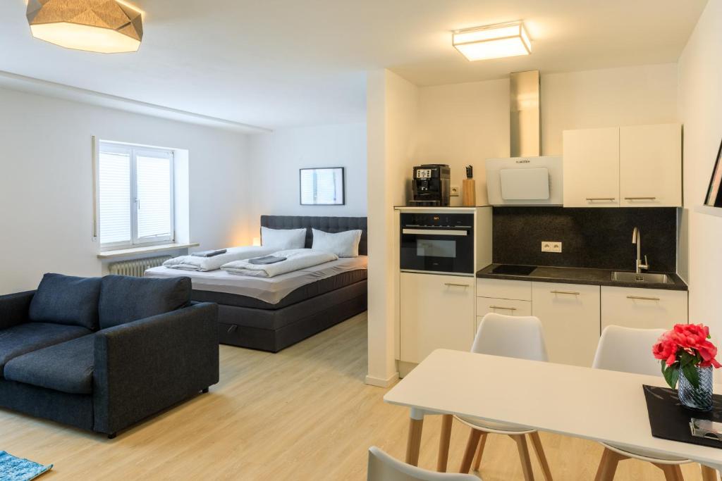 a kitchen and a living room with a couch and a table at Modern Apartment in city center in Würzburg