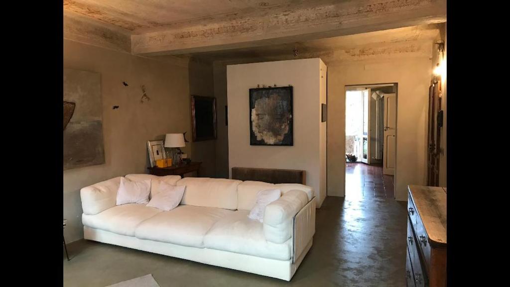 a living room with a white couch in a room at Casa luminosa con giardino in centro storico in Reggio Emilia