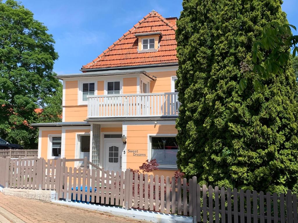 una casa amarilla con una valla blanca en SweetDreams - Stadtvilla von 1936 - bis 8 Pers - 150qm - 5 Schlafzimmer - 2 Bäder - Hunde willkommen en Bad Sachsa