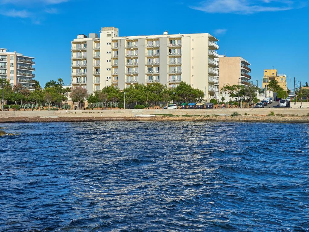 ein großes Gebäude am Ufer eines Wasserkörpers in der Unterkunft BQ Apolo Hotel in Can Pastilla