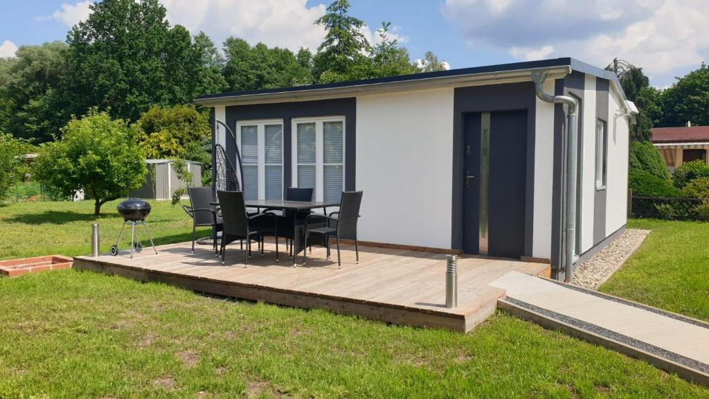 a tiny house with a table and chairs on a deck at Kranichnest in Rheinsberg