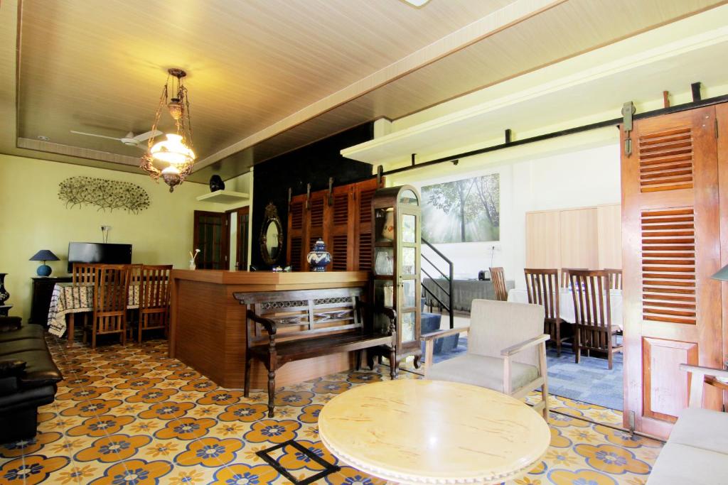 a living room with a table and a piano at Embe Joglo Homestay in Yogyakarta