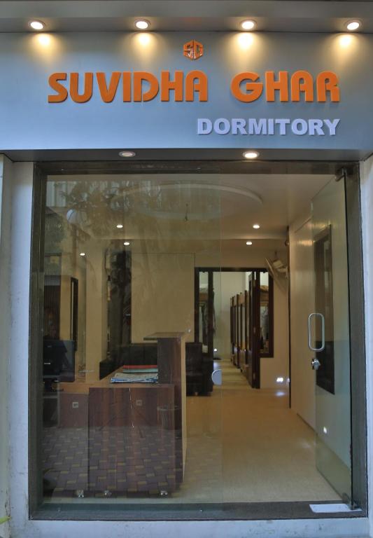 a window of a store with a sign on it at Suvidha Ghar AC DORMITORY in Surat