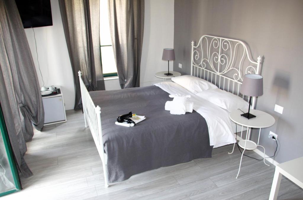 a bedroom with a white bed with a black cat on it at Del Toscano Home in Catania