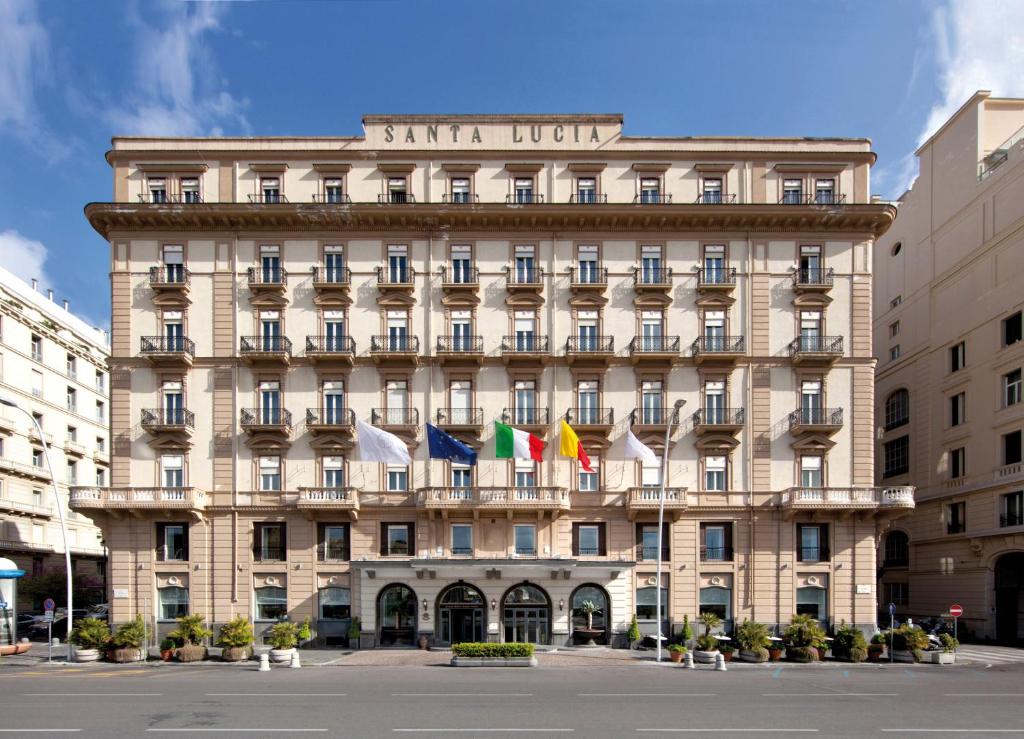 um edifício com bandeiras na frente em Grand Hotel Santa Lucia em Nápoles
