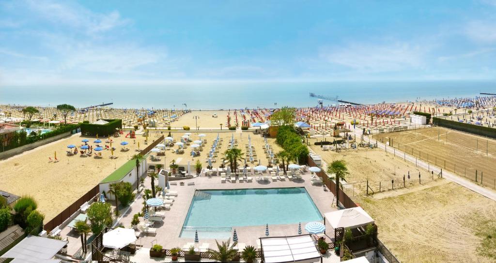 einen Strand mit Pool und eine Menschenmenge in der Unterkunft Hotel La Brezza frontemare in Lido di Jesolo