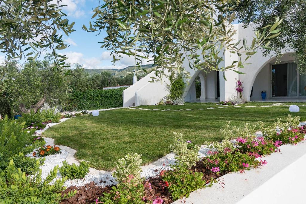 um jardim com flores e um edifício em B&B Casrienn em Mattinata