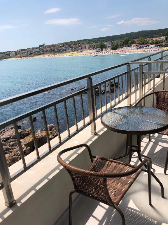 a balcony with a table and chairs and the beach at HARMONY in Sozopol
