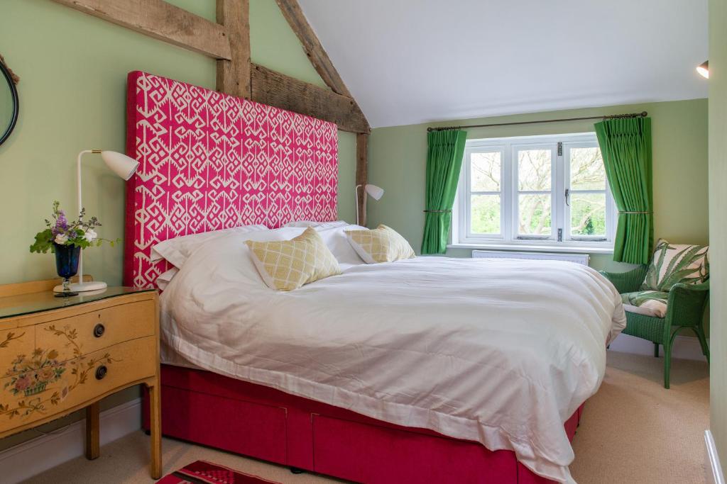 a bedroom with a large bed with a red headboard at The Hayloft, Wall End Farm in Leominster