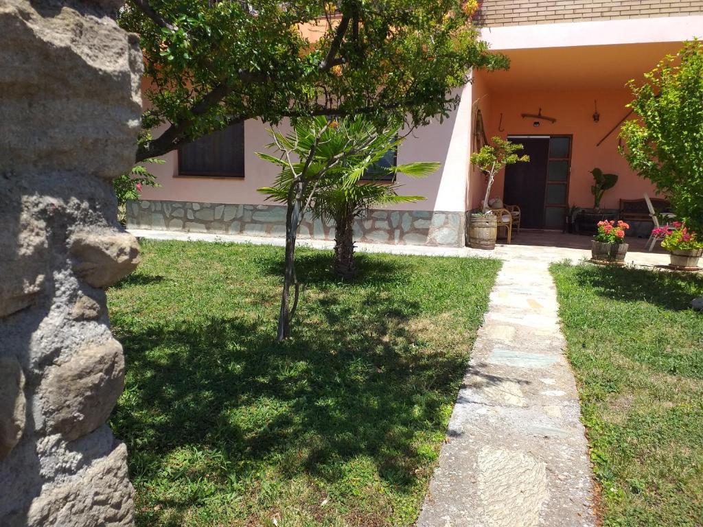 un jardín con un árbol y una casa en CASA el NOGAL, en Salas Bajas
