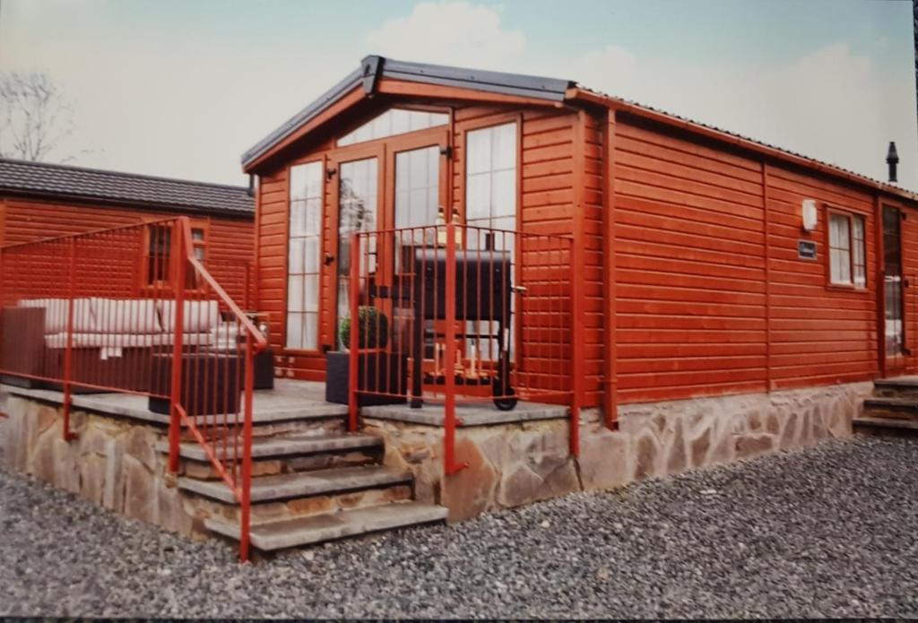 eine Holzhütte mit einer Treppe, die dorthin führt in der Unterkunft Craigrossie lodge33 in Auchterarder