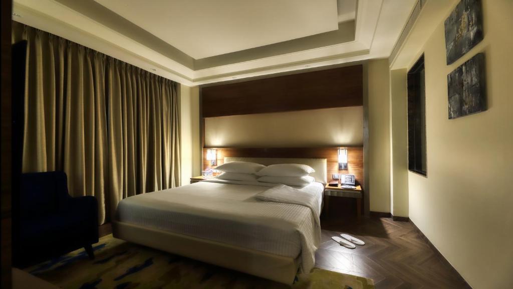 Postel nebo postele na pokoji v ubytování Ramada Gurgaon Central