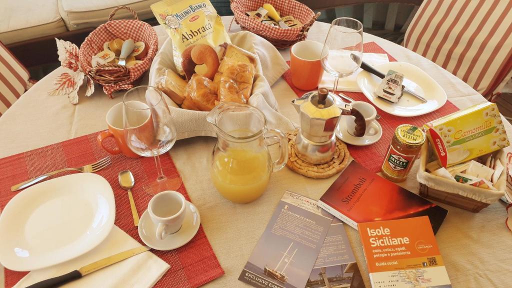 a table with breakfast food and orange juice on it at Osman Aga in Palermo