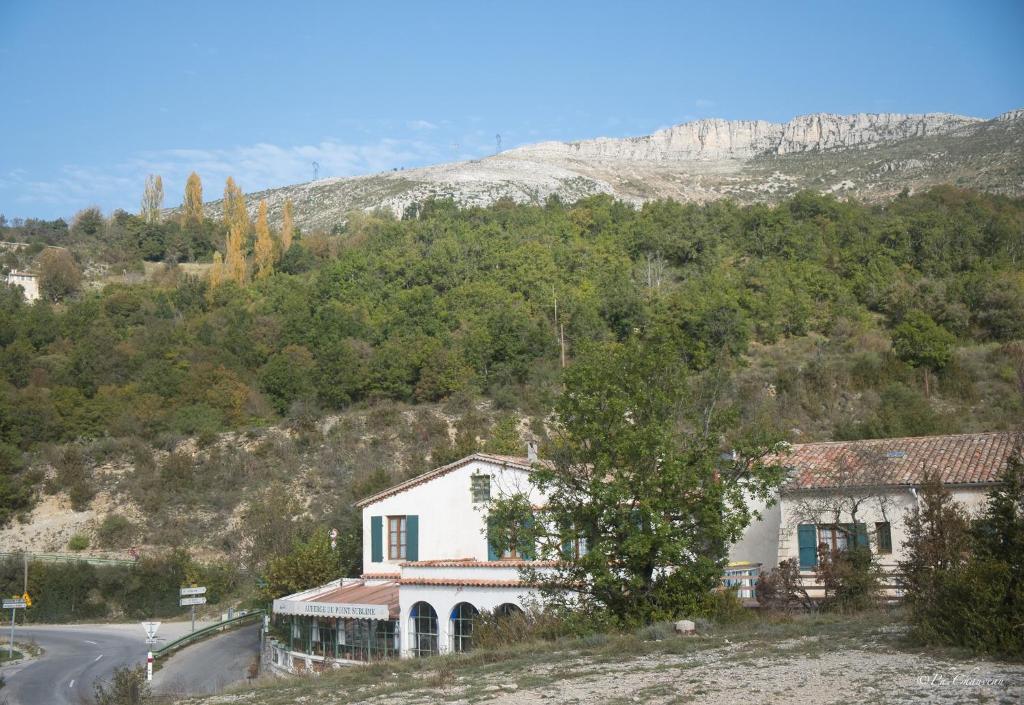 une maison sur une colline à côté d'une route dans l'établissement Auberge du Point Sublime, à Rougon