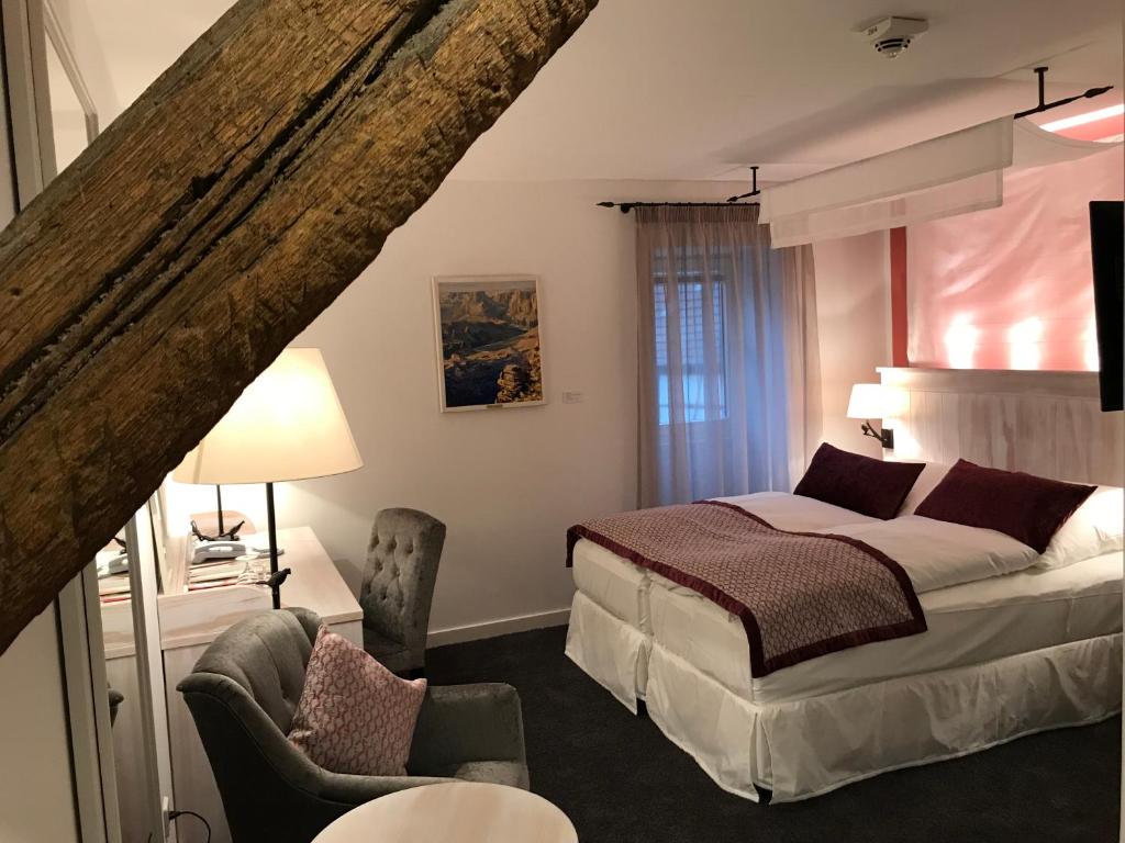 a bedroom with a bed and a chair at Altes Amtshaus, 3-Sterne Hotel Garni Superior in Mulfingen-Ailringen