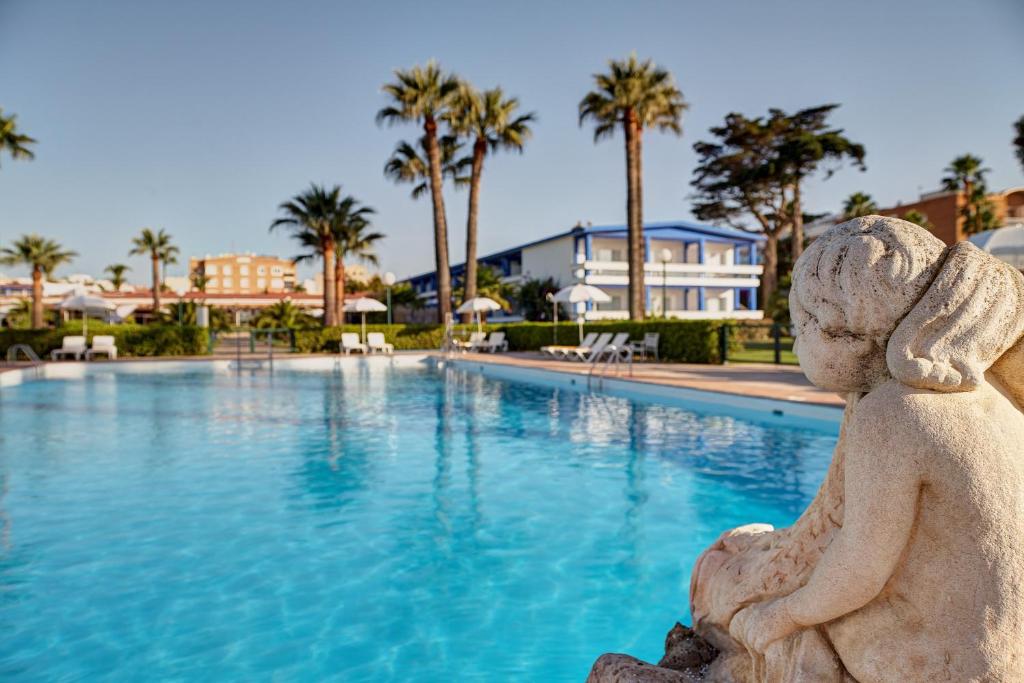 
a large swimming pool with a statue of a man in it at Parador de Benicarló in Benicarló
