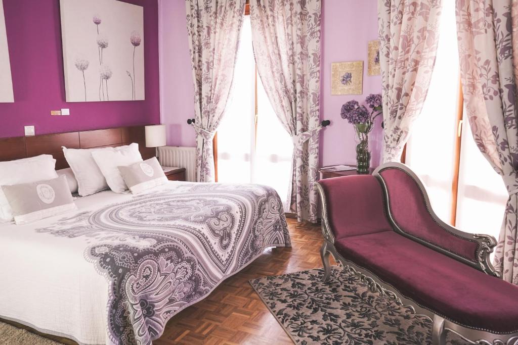 a purple bedroom with a bed and a chair at Hostal Docar in Lerma