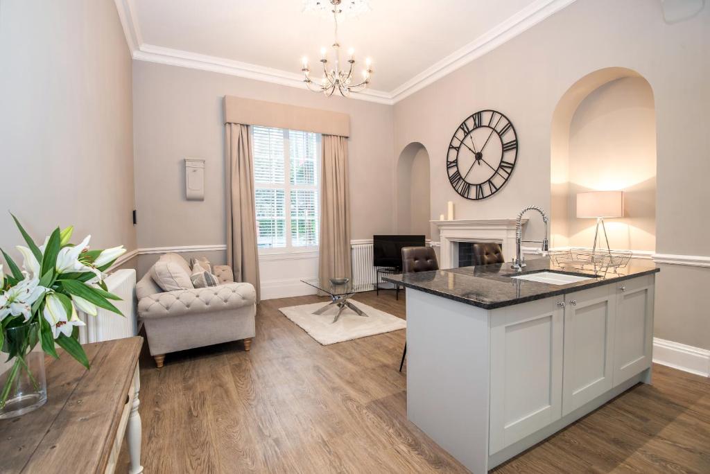 a kitchen and living room with a clock on the wall at 52 Old Elvet in Durham