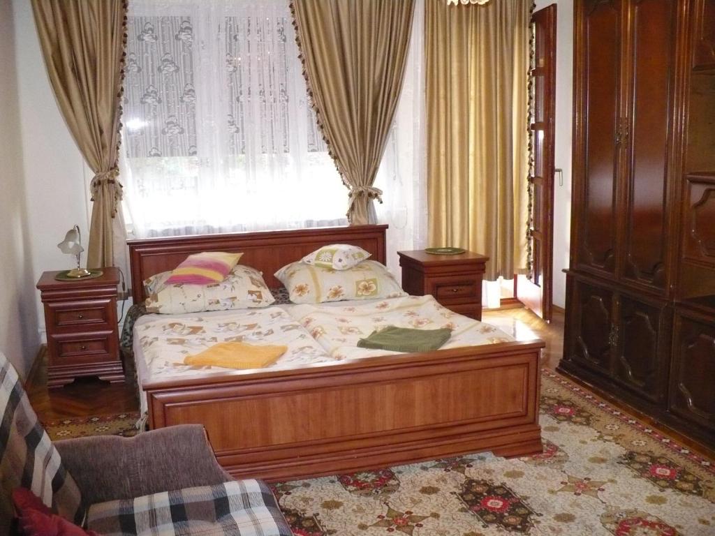 a bedroom with a bed and a window at Kitty Apartman in Miskolctapolca