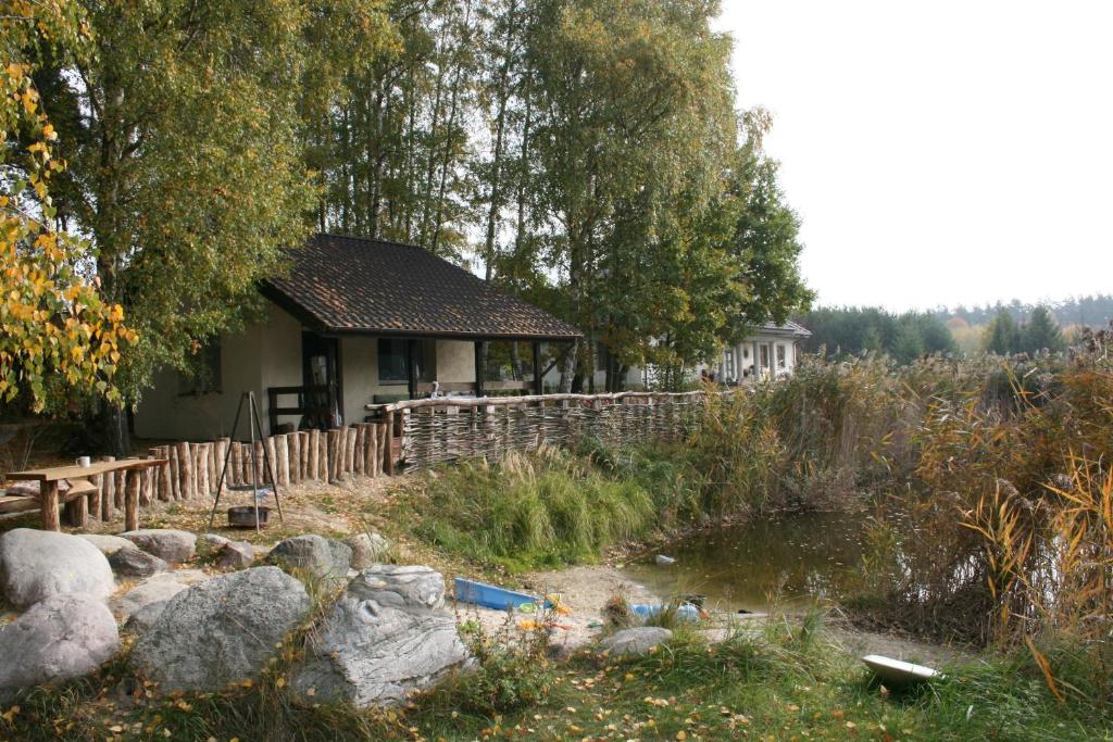 uma casa com um lago em frente em Agroturystyka Zatom Stary em Zatom Stary