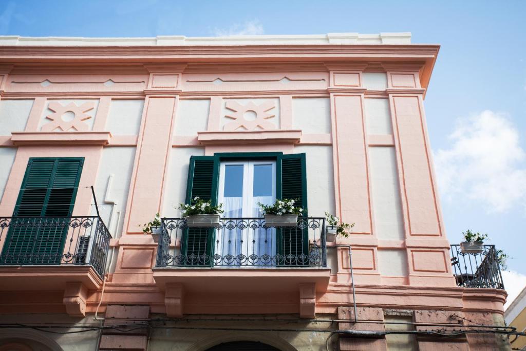 a building with green shutters and potted plants on a balcony at Le Dimore dell'Acqua in Matera