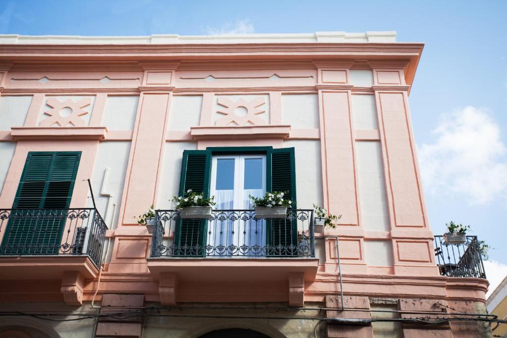 un edificio con persianas verdes y macetas en un balcón en Le Dimore dell'Acqua, en Matera