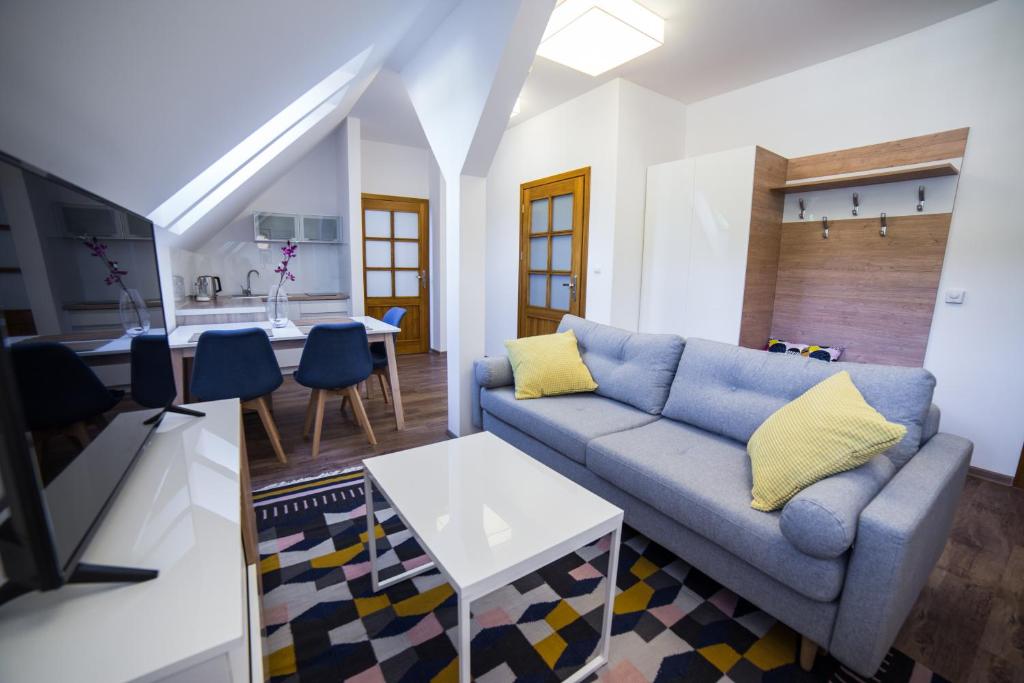 ein Wohnzimmer mit einem blauen Sofa und einer Küche in der Unterkunft Apartament Miejski in Wisła
