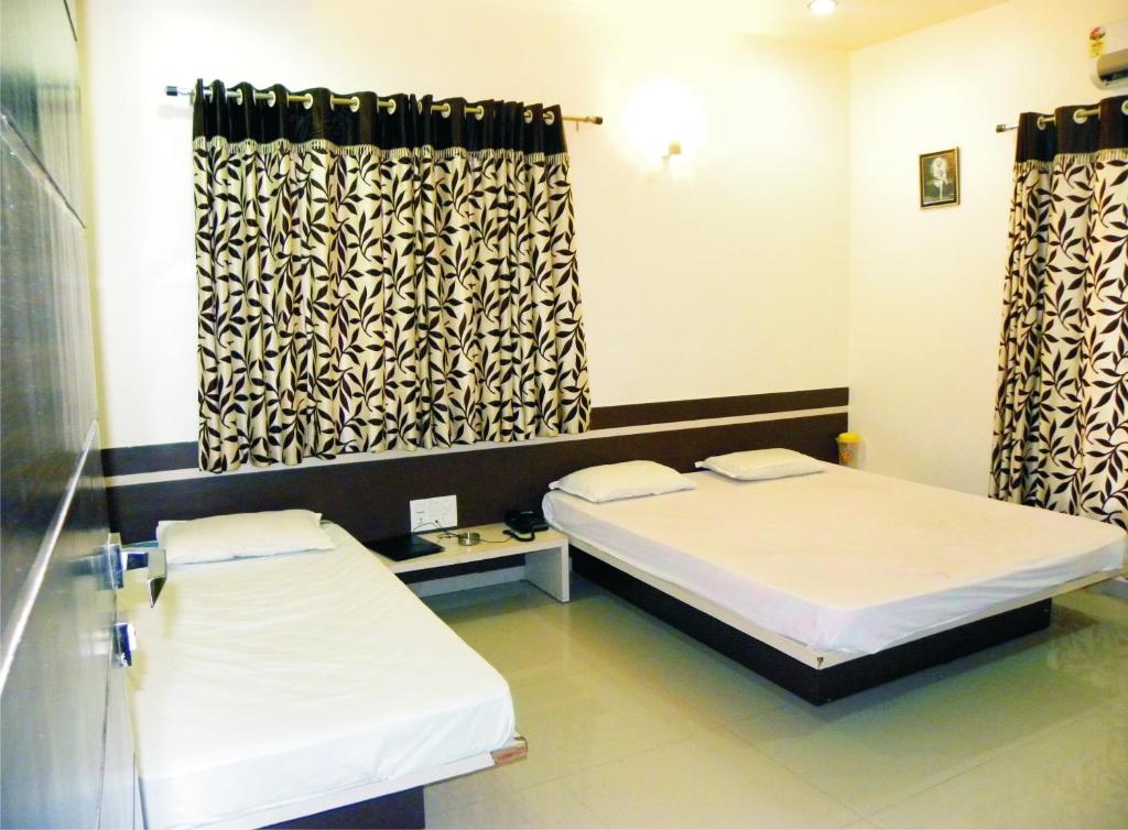 Postel nebo postele na pokoji v ubytování Hotel Shradha Saburi Palace