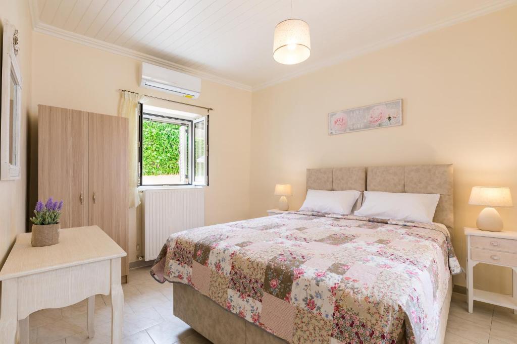 a bedroom with a bed and a table and a window at MarGreCo in Garitsa in Corfu