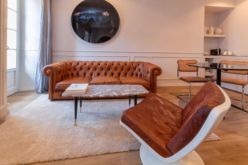 a living room with a brown couch and a table at Suites Menaggio in Menaggio